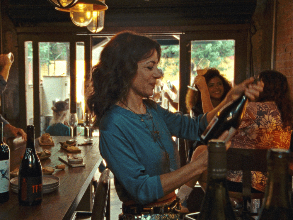 Woman looks at wine bottle in wine bar
