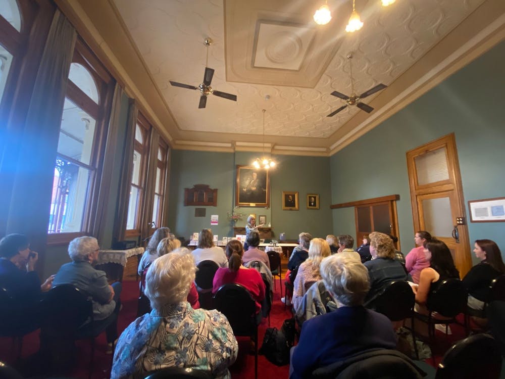 An interested crowd listening to an author speak about their work.