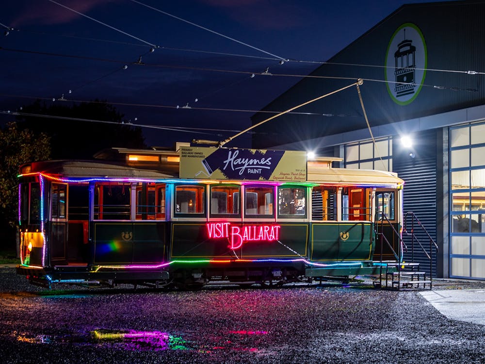 An illuminated heritage tram outside the Museum
