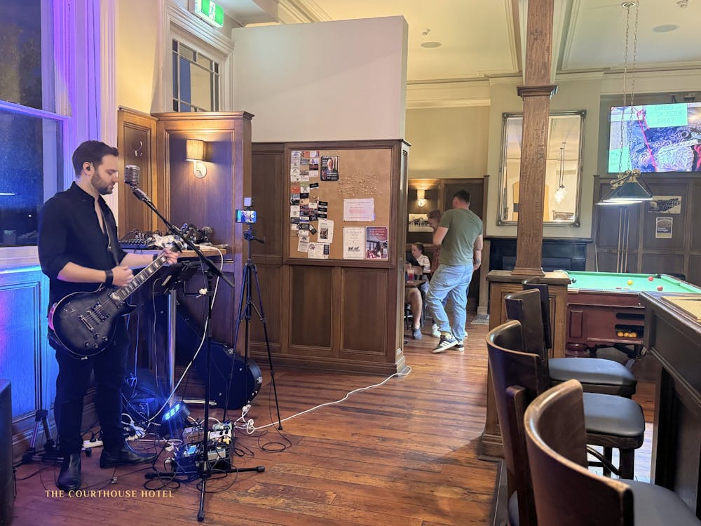Musicians performing live music inside the Courthouse Hotel with guests enjoying the venue.