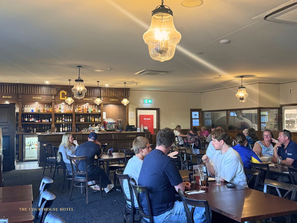 Patrons seated at tables eating and socialising inside the Courthouse Hotel dining area.
