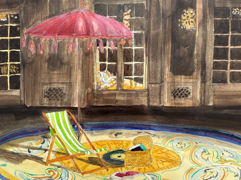 stiped deckchair on round yellow carpet with red beach tasseltedumbrella