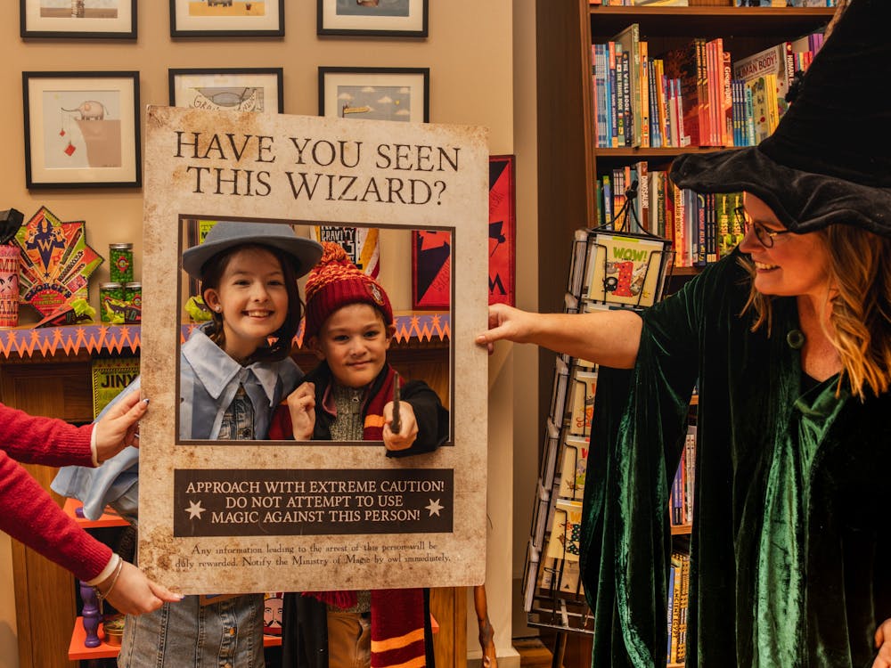 Two children dressed in Harry Potter costumes are posing in a photo frame at Collins on Lydiard