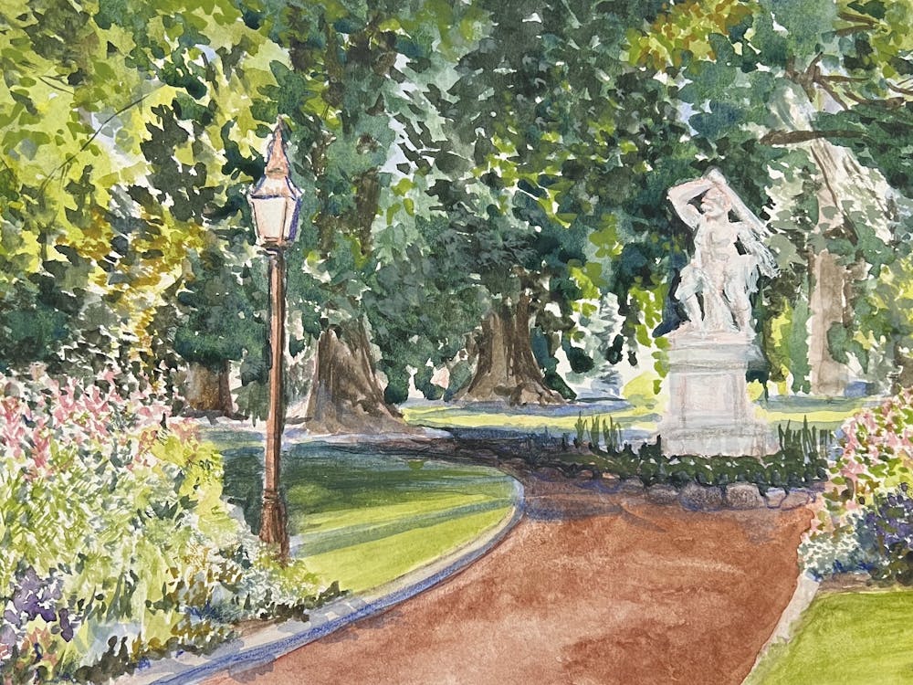 brown path in gardens with marble sculpture and overhanging trees on a sunny day