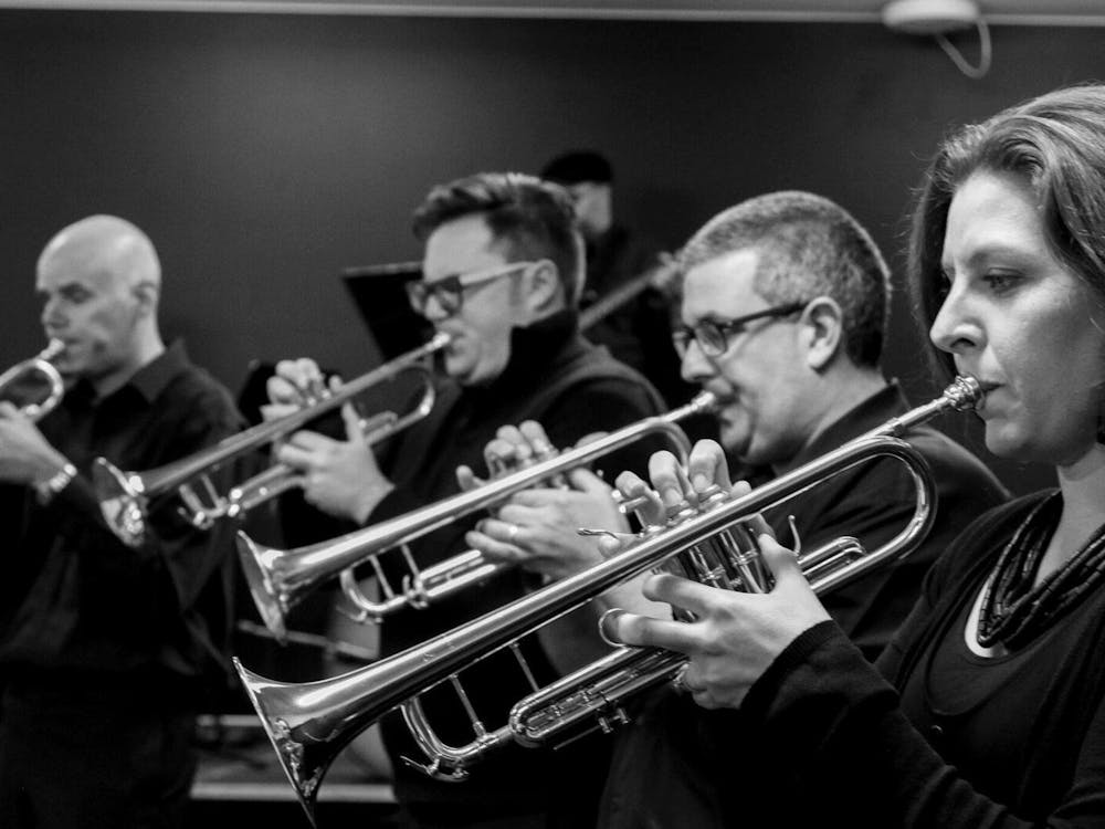 Four people playing trumpets.