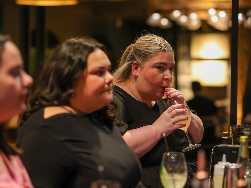 woman sipping on a cocktail at Itinerant Spirits cocktail making class