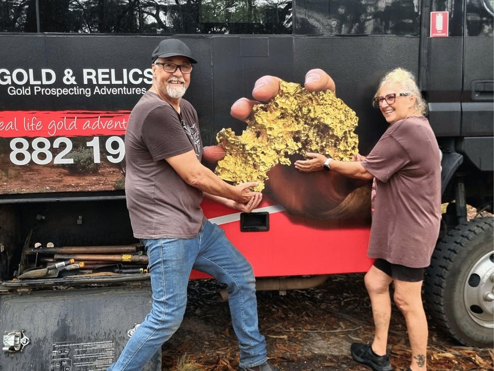 Visitors gathered in front of the Gold & Relics bus at a goldfields tour location.