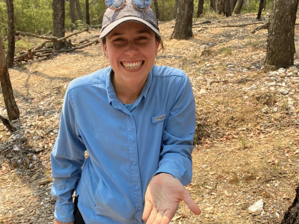 Smiling guest holding a small gold nugget found during a guided prospecting adventure.
