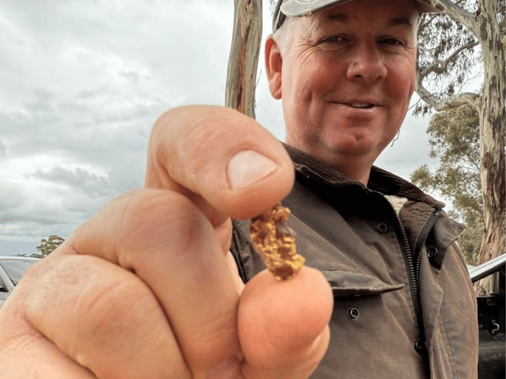 Happy prospector holding freshly discovered gold in the Victorian goldfields.