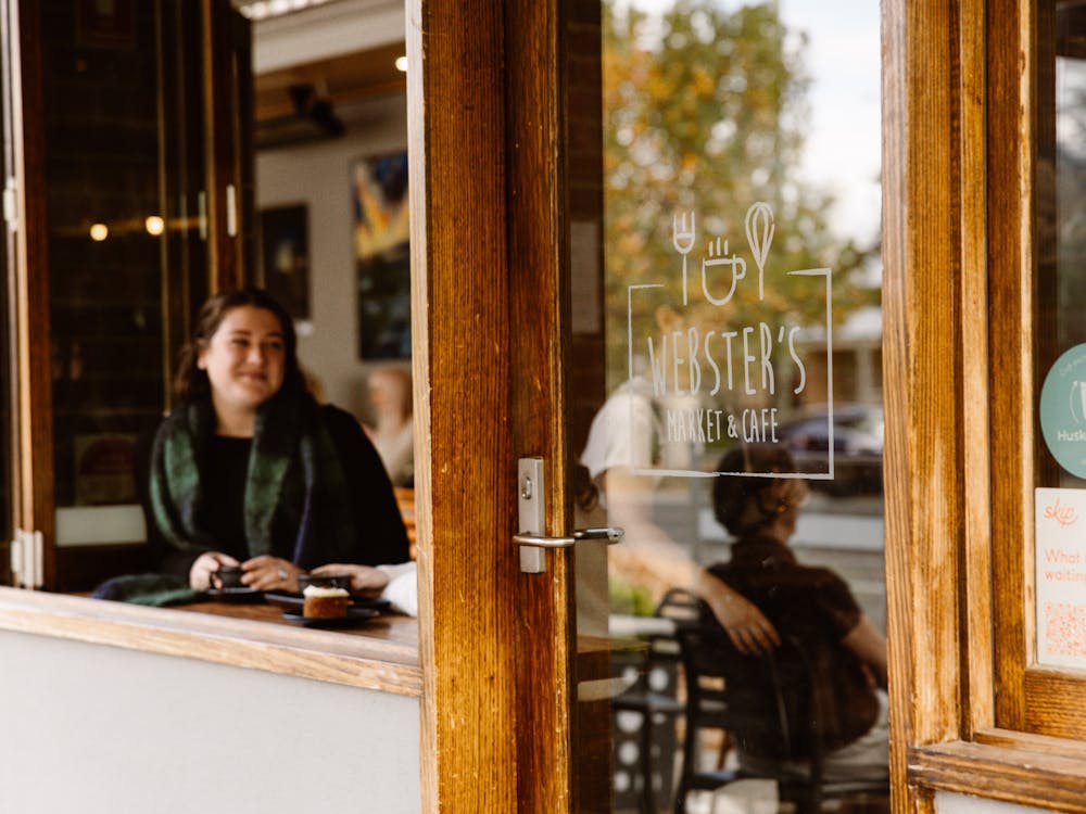 Customer enjoying coffee at the window inside Webster's Market and Cafe.