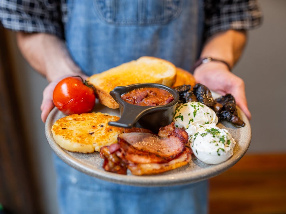 Staff member carrying Webster's signature cooked breakfast.