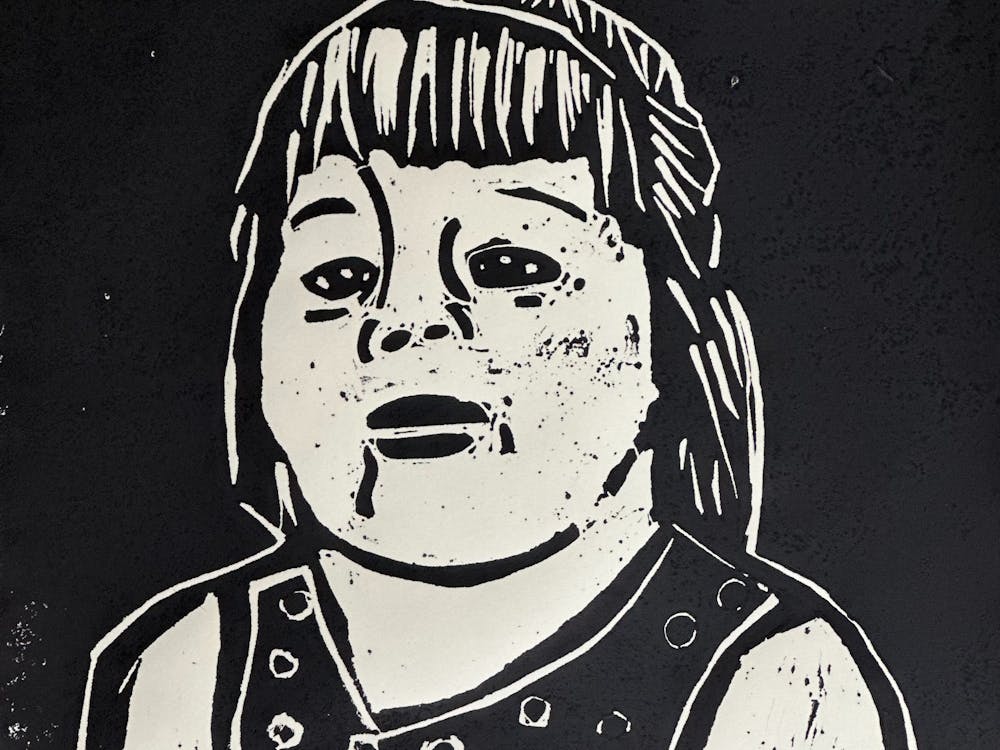 A black and white portrait in lino print of a woman with long hair and a black top.