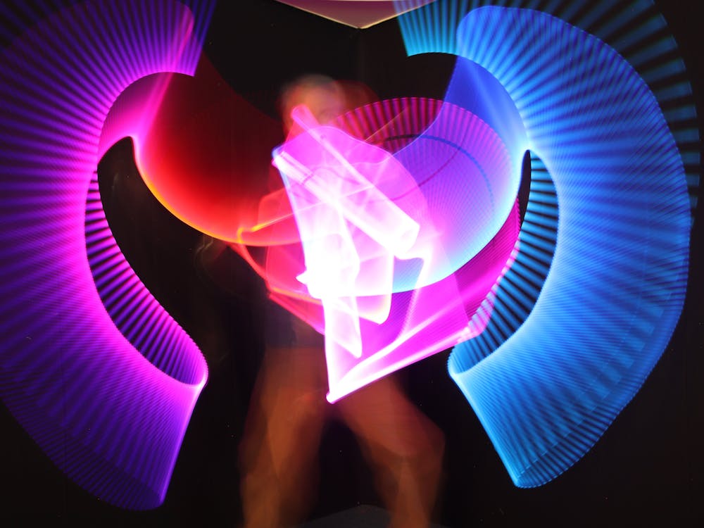 Bright patterns in blue, purple and red draw with light, captured by a photographer .