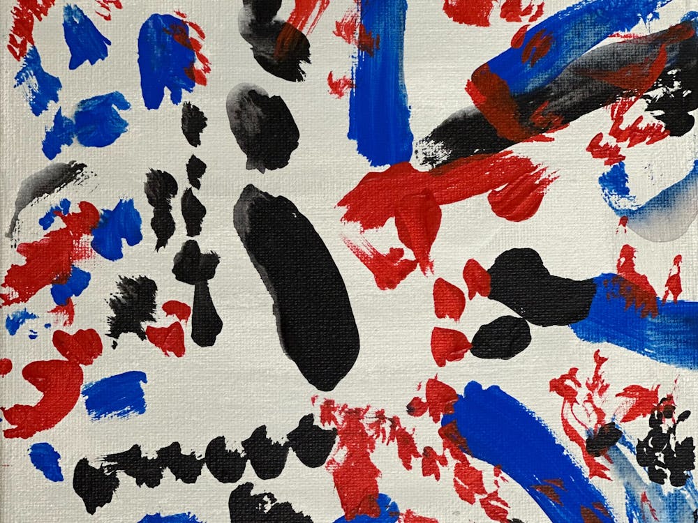 Blue, red and black markings on a white background creating an abstract work.