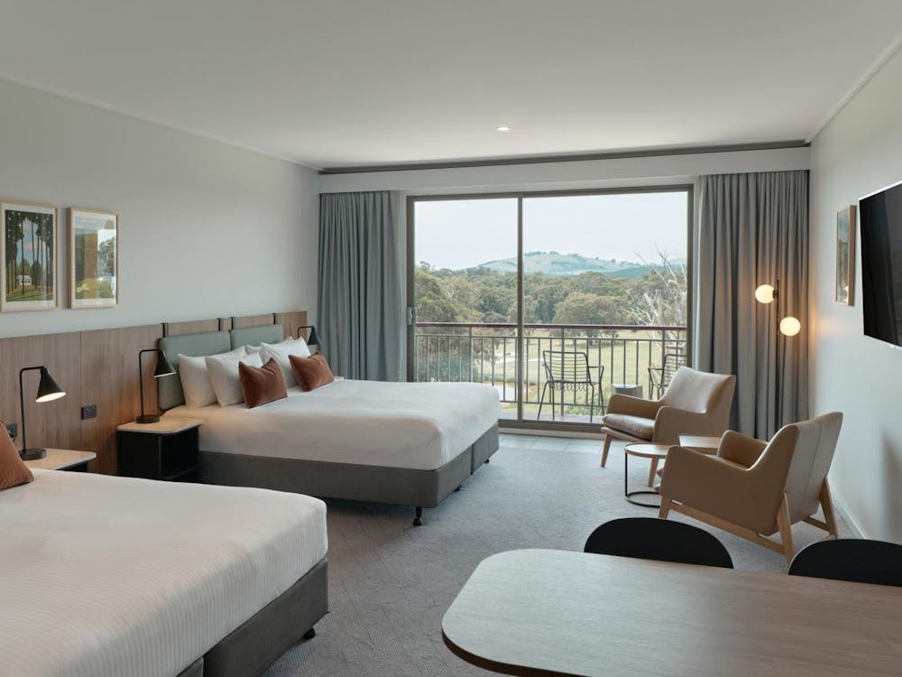 Fairway Room featuring beds, arm chairs, TV and dining table.