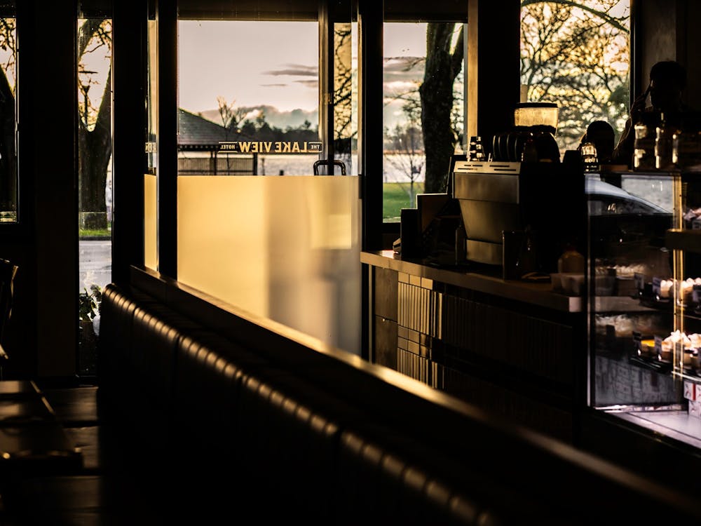 Interior café seating with views through the windows towards Lake Wendouree at sunset.