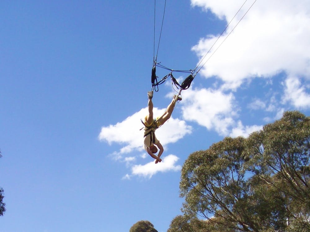 A person swings upside down on a giant swing harness