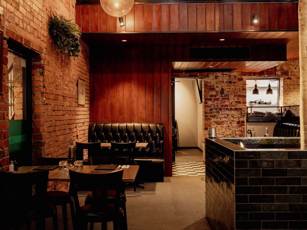 Dining area inside The North Star Hotel with timber finishes, exposed brick and comfortable booth