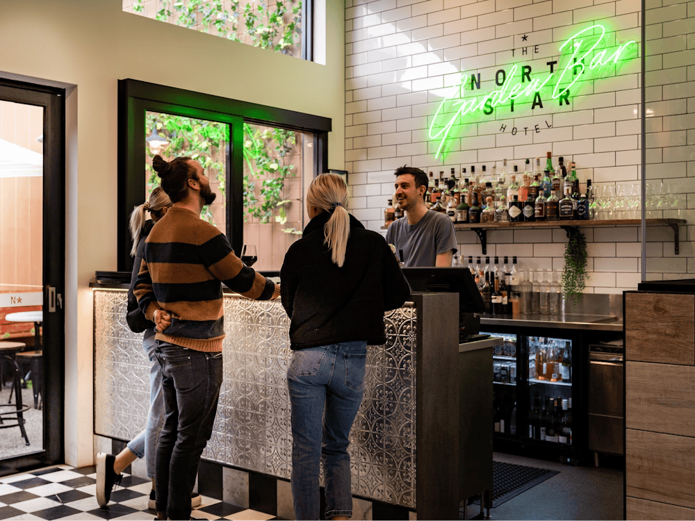 Guests ordering drinks at the bar inside The North Star Hotel.