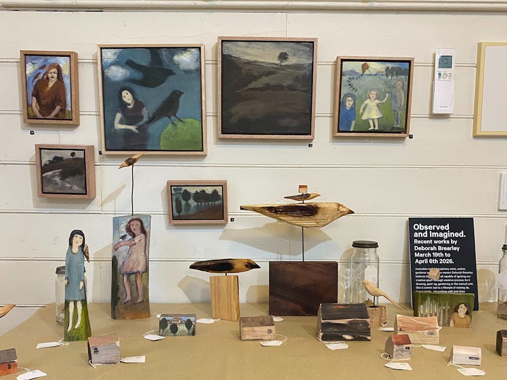 a collection of small paintings and sculptures on display
