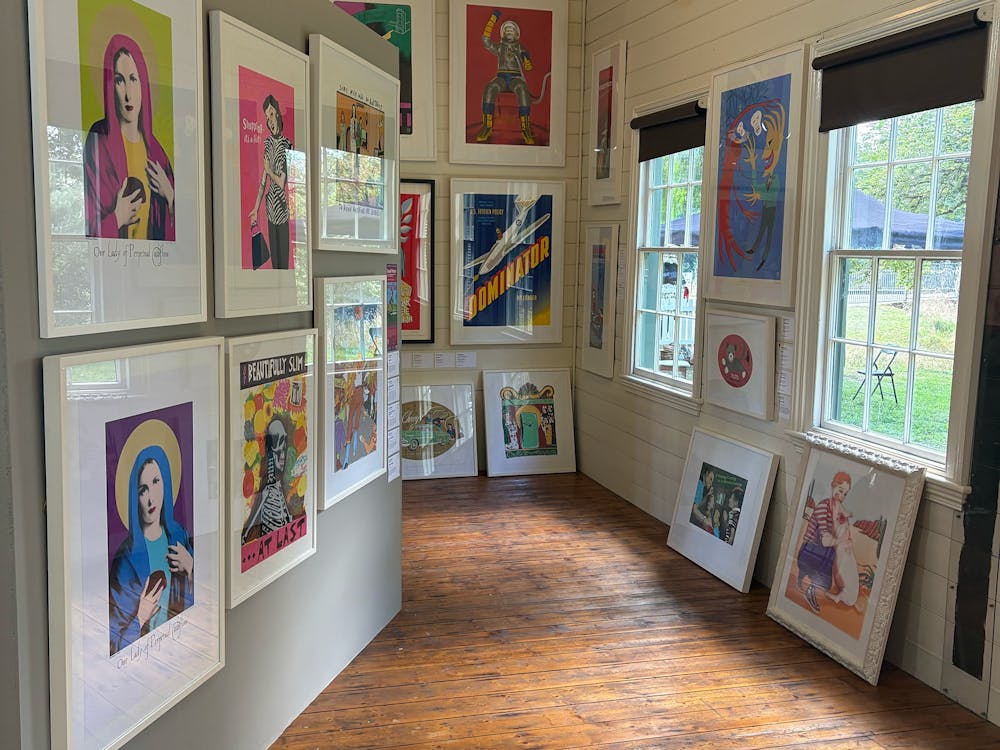 Colourful framed screenprints covering the walls of a timber heritage gallery interior, Clunes.