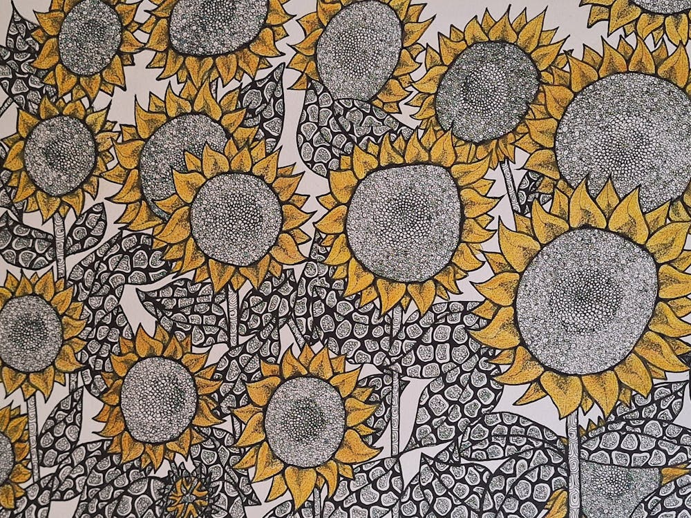 Multitude of sunflowers with patterned detail in black pen with yellow watercolour