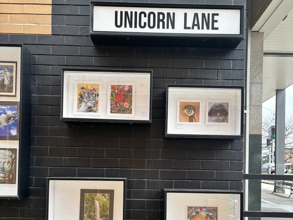 Outdoor gallery boxes on a wall displaying the collages of the current exhibition.