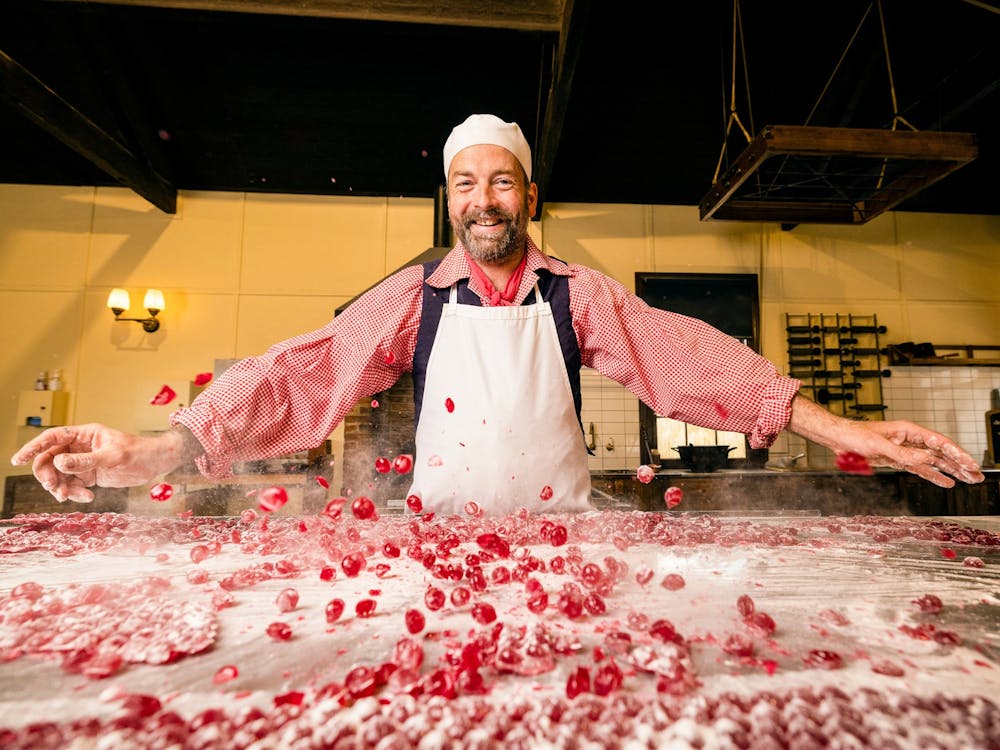 Confectioner smashing Raspberry Drops on bench