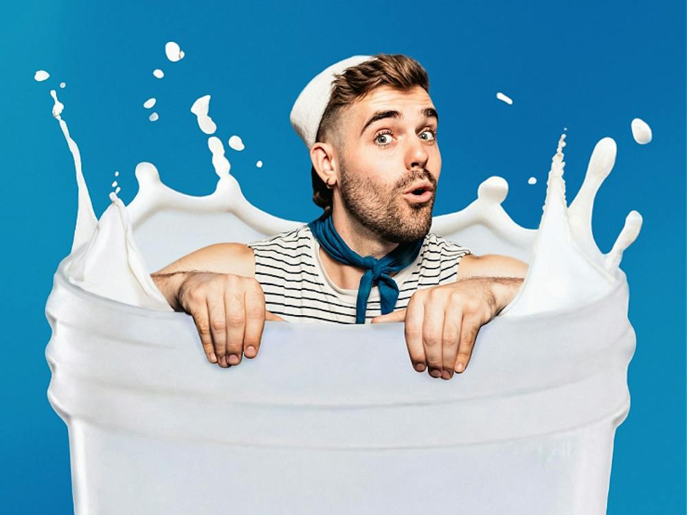 Portrait of artist splashing in a milky bottle - in a sailor outfit