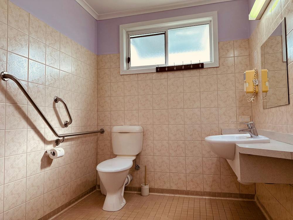 Family Room accessible bathroom with shower, toilet and handrails at Stonez Boutique Accommodation