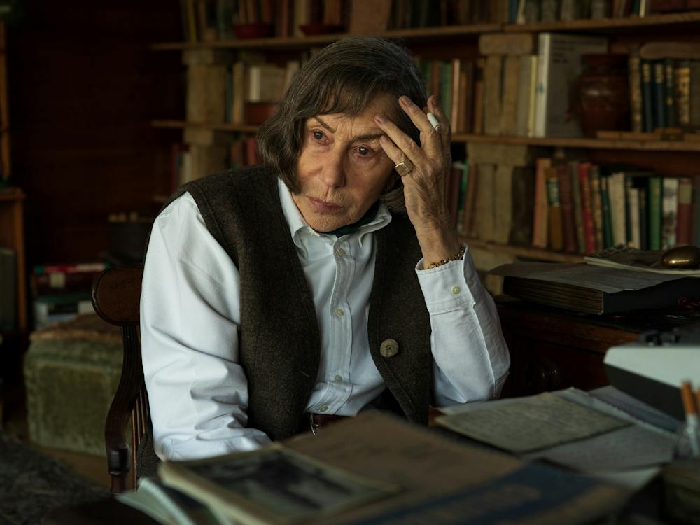 Woman sits at writing desk