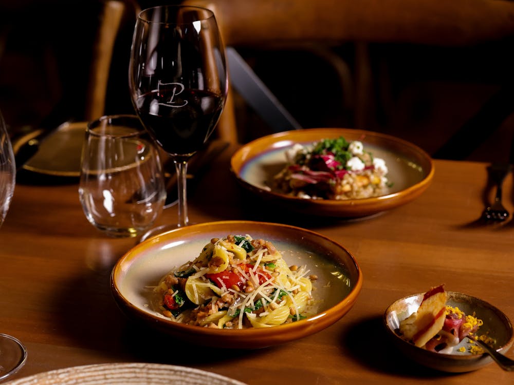 Dishes served with wine glasses at Peasant Osteria