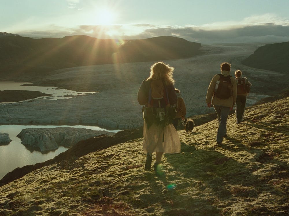 Family walking on a hillside into the rising sun
