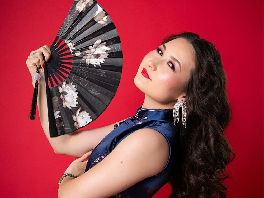 Portrait of artist with fan on red background